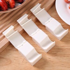 3-piece set of white ergonomic crawfish peeling tools on a wooden kitchen board