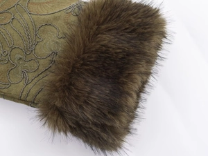 Close-up of olive green fabric with intricate embroidery and fluffy brown faux fur trim