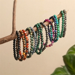 Bracelets en perles de pierre de cristal naturel multicolores sur une branche en bois