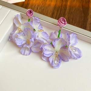 Macro detail of purple fabric flower earrings with long fringe and water drop pendant
