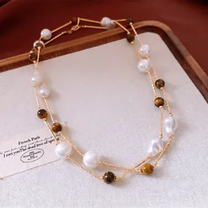 Élégant collier vintage double rang en œil de tigre et perles sur un plateau en bois