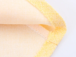 Vista macro della trama del tessuto in tweed giallo con bordi orlati e cuciture di alta qualità