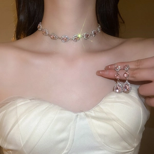 Close-up of elegant pink teardrop necklace and earrings set worn by a model