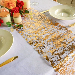 Close-up of golden foil pattern on sheer mesh table runner for elegant wedding decor