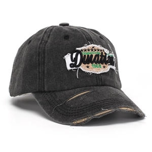 Detail of vintage washed black baseball cap with distressed embroidery and frayed brim