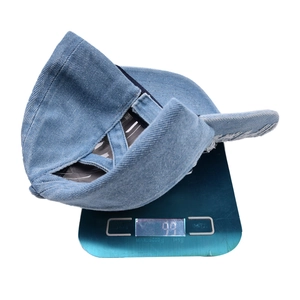Weight detail of distressed denim ponytail cap with elastic criss-cross back design.
