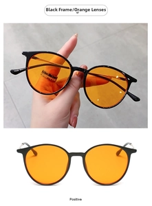 Detail view of round black frame sunglasses with orange lenses and model 9328 engraving