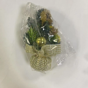 Detailed view of mini Christmas tree in clear plastic wrap with gold ribbon base