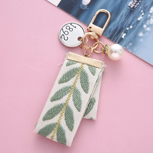 Porte-clés élégant en ruban rayé avec perle et broderie de feuilles sur fond rose