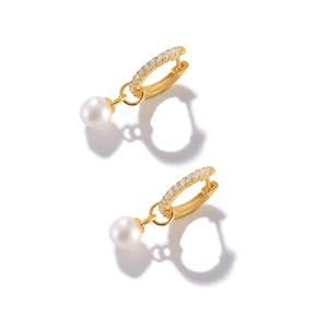 Macro detail of gold pearl drop earrings with sparkling pavé zircons and smooth white finish