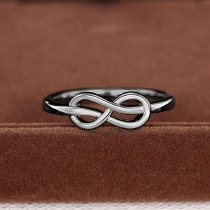Macro-opname van een donker metalen infinity ring op bruine fluwelen display gepolijst