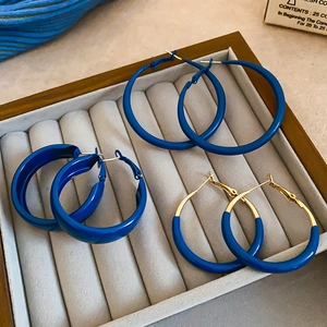 Three pairs of Klein blue earrings in a wooden jewelry tray with velvet lining