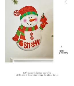 Detail of Christmas snowman sticker with red glitter hat, scarf and SNOW text on white wall