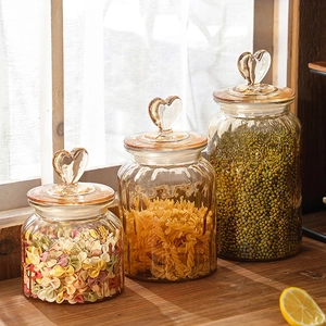 Three amber heart-shaped handle glass jars with vertical textures on a wooden window sill
