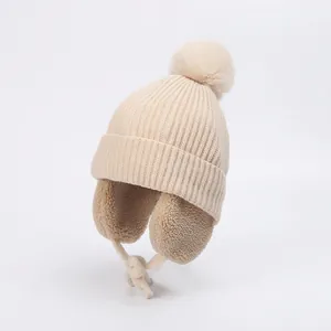 Detailed view of winter baby knit hat featuring cream ribbed fabric and warm fleece lining