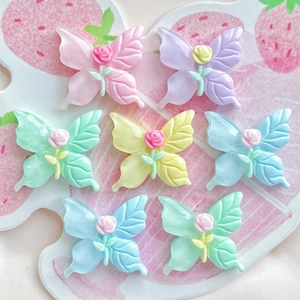Pastel butterfly resin charms with rose center displayed on a decorative palette tray