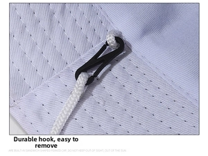 Detail of a black quick-release hook and woven strap on a white breathable sun hat