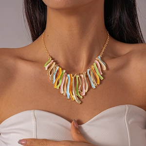Detailed close-up of a golden tassel necklace with colorful macaron enamel charms on model