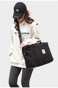 Detailed view of the black quilted yoga bag worn by a model in a fitness setting