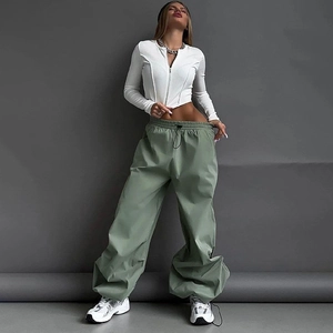 Dettaglio della giacca bianca slim fit con zip e pantaloni cargo larghi verde oliva