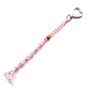 Detailed close-up of pink handwoven cotton cord keychain with heart clasp and wooden bead
