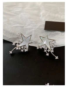 Detail of silver shooting star earrings featuring white mother-of-pearl and cubic zirconia