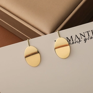 Polished gold oval earrings with minimalist geometric design and thin hooks