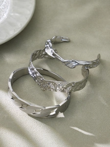 Macro shot of silver textured bracelets set featuring hammered finish and lava irregular design