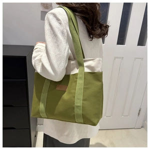Detail of olive green and beige canvas tote bag with matching fabric shoulder strap
