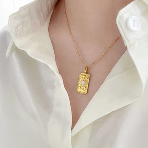 Detailed close-up of The Moon tarot card gold pendant on a stainless steel chain