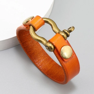 Detailed macro view of orange leather strap with antique brass shackle clasp buckle