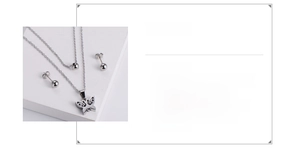 Detail of silver stainless steel jewelry set with butterfly pendant and ball earrings