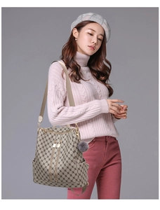 Detail view of fashion monogram backpack with dual zippers and plush ball charm on model