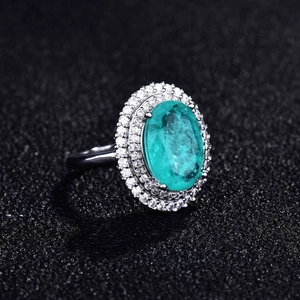 Macro shot of oval Paraiba blue stone ring with double halo micro-pave diamonds