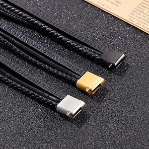 Gros plan d'un bracelet en cuir multicouche avec fermoirs magnétiques noir or argent