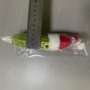 Size measurement of green plush banana keychain in red Christmas outfit with metal ruler
