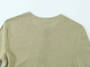Macro detail of olive green linen blend fabric texture on the back neckline and shoulder