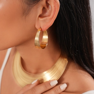 Close-up of a high-shine golden multi-layer collar necklace and chunky earring set