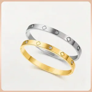 Polierte Armreifen aus Titanstahl mit Kleeblatt-Motiven und Kristallen in Gold und Silber