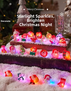 Macro view of glowing Christmas LED rings featuring Santa and snowman on snowy props