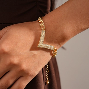 Macro shot of gold V-shaped bracelet with cubic zirconia paving on chunky link chain