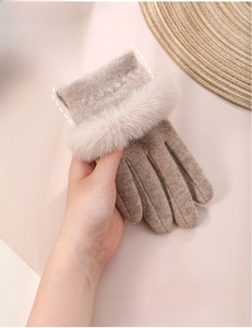 Detail of warm beige knit gloves with faux fur trim and touch screen index finger