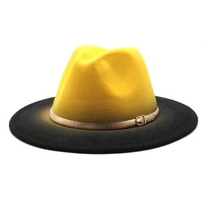 Détail d'un chapeau fedora en laine bicolore jaune et noir avec boucle en métal doré
