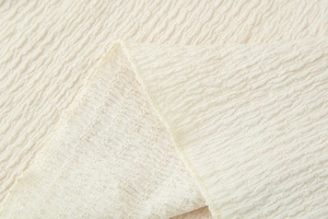 Close-up of cream-colored seersucker fabric with detailed crinkle texture and soft finish