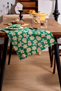 Detail of Christmas napkin cloth with gingerbread man and festive prints on dark wood table