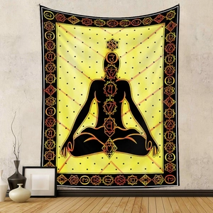 Detail of bohemian yellow tapestry with seven chakras and meditation silhouette on wall