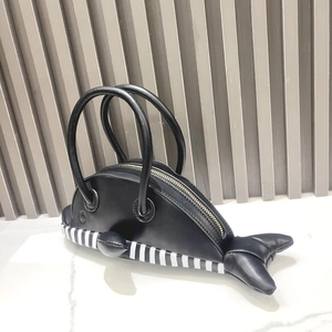 Detailed view of the creative whale-shaped handbag with striped belly and golden zipper