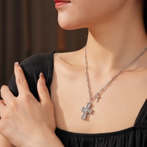 Close-up of double cross necklace with vintage rhinestone pendant on a silver chain
