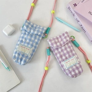 Close-up of quilted camera bag texture with Sorakka logo label and colorful rope strap
