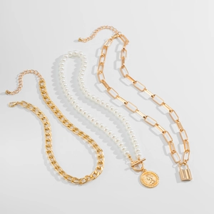 Close-up of layered baroque pearl necklace with gold cuban and paperclip chains